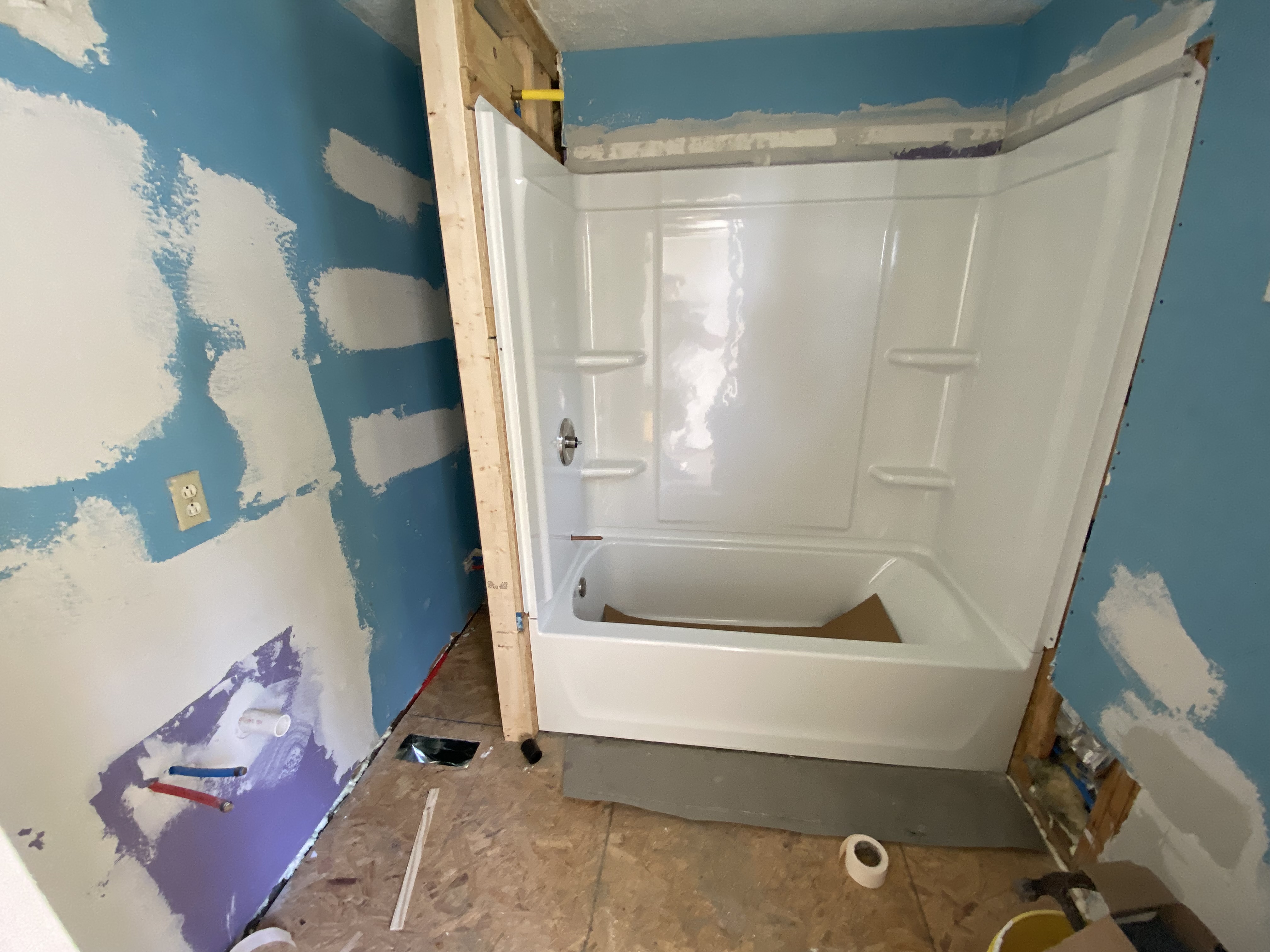 Shower and tub combo set with drywall patch on this bathroom